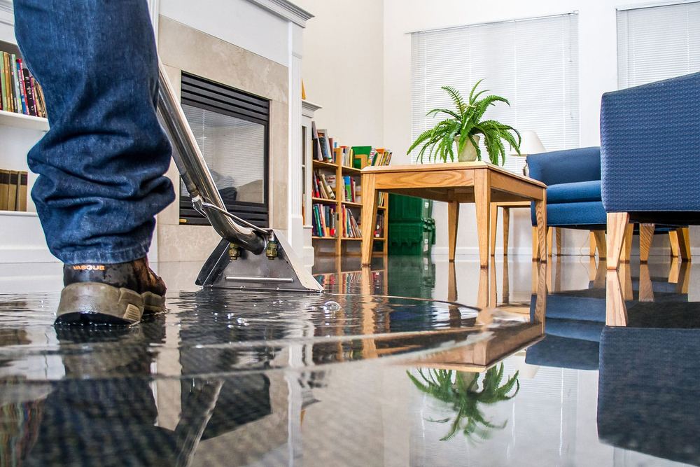 Technician extracting water from a hardwood floor after a leak